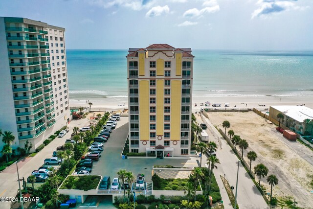 view of building exterior featuring a water view and a beach view