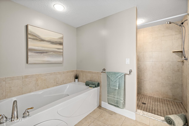 bathroom with tile patterned flooring, a textured ceiling, and separate shower and tub