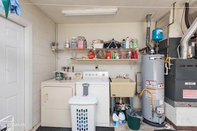 clothes washing area with washer and dryer, gas water heater, and sink