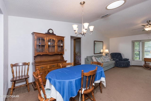 carpeted dining space featuring ceiling fan with notable chandelier, a textured ceiling, and lofted ceiling