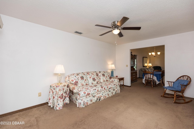 carpeted living room featuring ceiling fan with notable chandelier and a textured ceiling