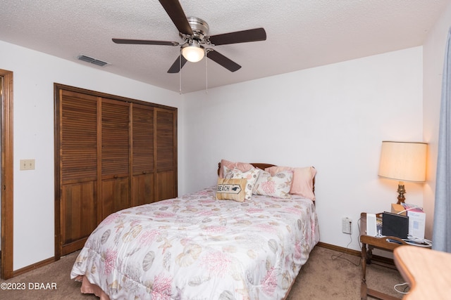 carpeted bedroom featuring a textured ceiling, a closet, and ceiling fan