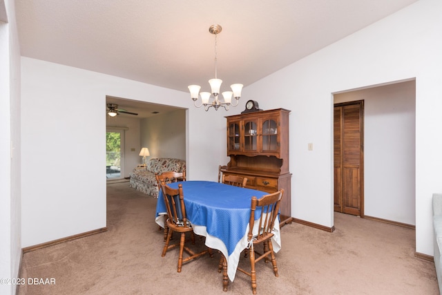 dining room featuring ceiling fan with notable chandelier and light colored carpet