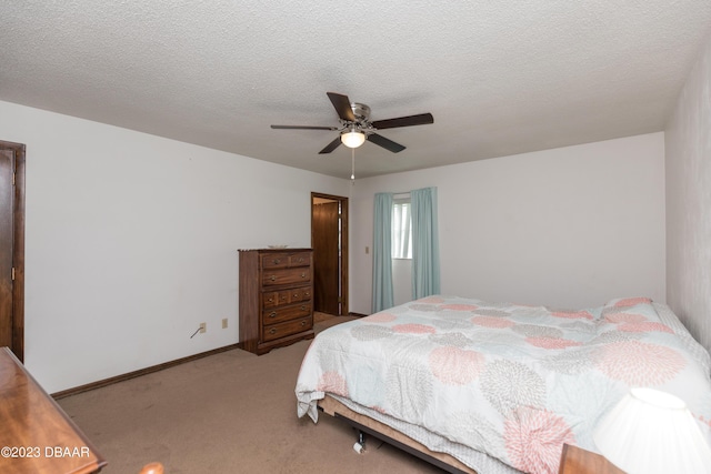 bedroom with ceiling fan, light colored carpet, and a textured ceiling