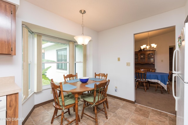 dining area with vaulted ceiling and an inviting chandelier