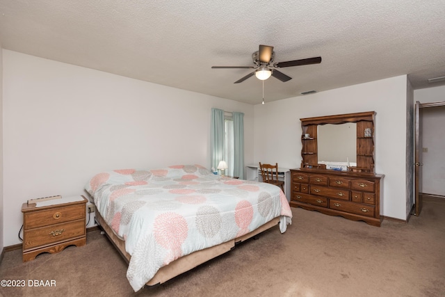 carpeted bedroom featuring a textured ceiling and ceiling fan