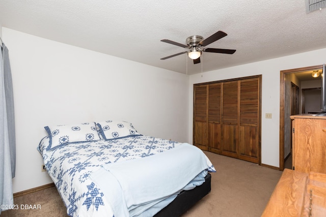 carpeted bedroom featuring ceiling fan, a textured ceiling, and a closet