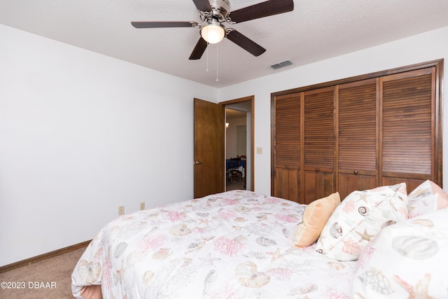 bedroom featuring carpet, a textured ceiling, a closet, and ceiling fan