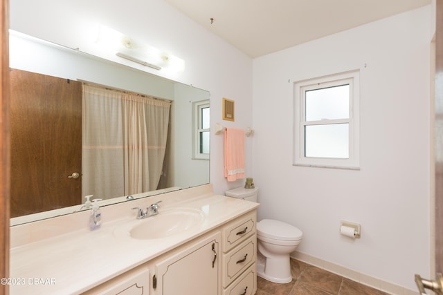 bathroom featuring tile patterned flooring, vanity, and toilet