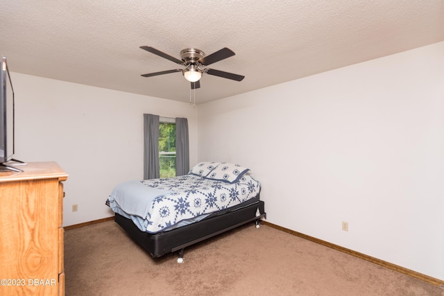 bedroom with ceiling fan, carpet floors, and a textured ceiling