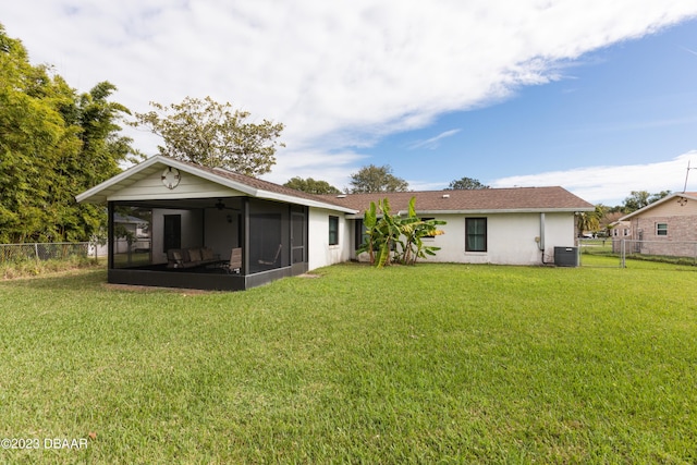 back of property featuring a sunroom, a lawn, and central AC