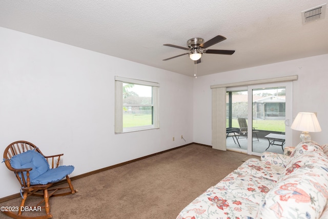 living room with a textured ceiling, carpet floors, plenty of natural light, and ceiling fan