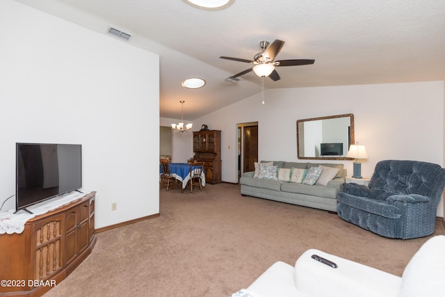 carpeted living room featuring ceiling fan with notable chandelier and vaulted ceiling