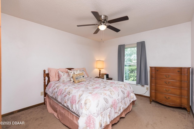 carpeted bedroom with ceiling fan and a textured ceiling