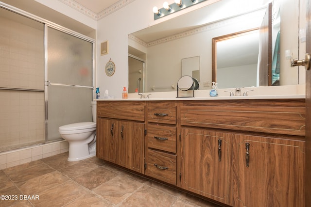 bathroom featuring vanity, toilet, and a shower with door