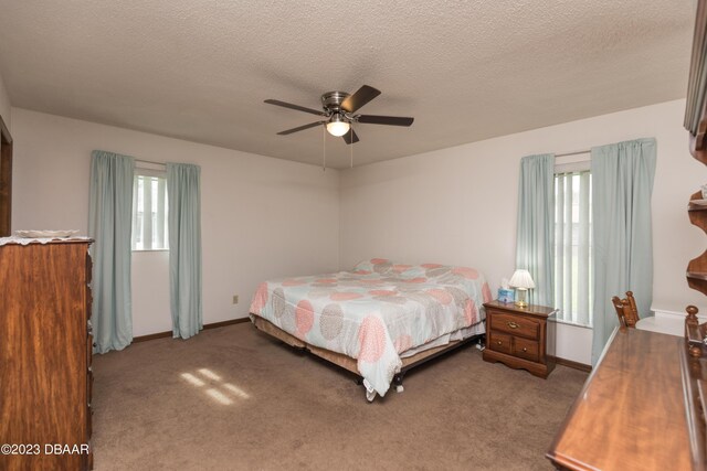 carpeted bedroom with ceiling fan and a textured ceiling