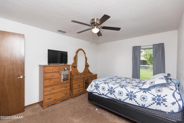 bedroom with carpet flooring, ceiling fan, and a textured ceiling