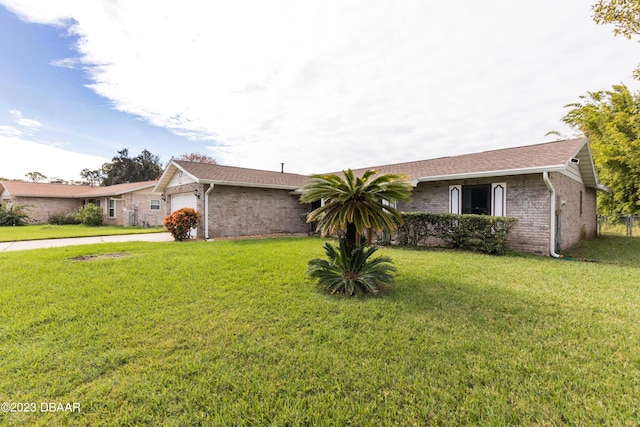 ranch-style home with a garage and a front lawn