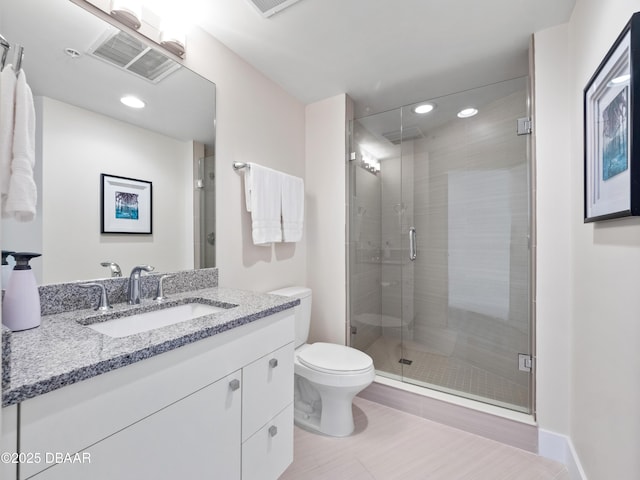 bathroom with vanity, visible vents, toilet, and a shower stall