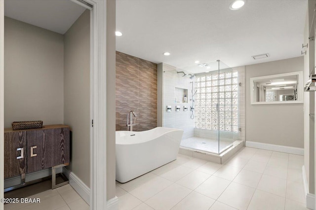 full bathroom featuring recessed lighting, a freestanding bath, tile walls, and a stall shower