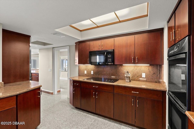 kitchen featuring tasteful backsplash, visible vents, baseboards, light stone counters, and black appliances