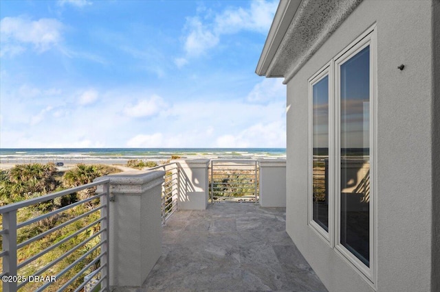 balcony featuring a water view and a view of the beach