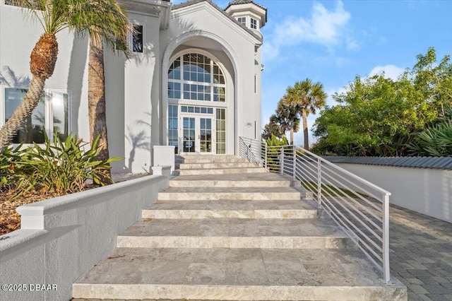 entrance to property featuring french doors and stucco siding