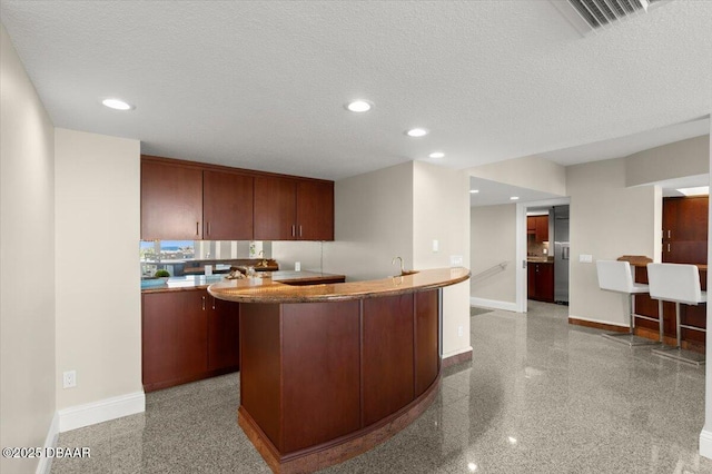 kitchen with recessed lighting, baseboards, and a textured ceiling