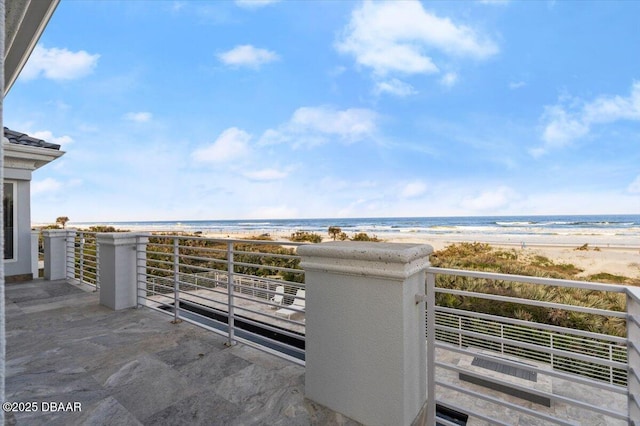 balcony featuring a view of the beach and a water view