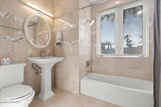 bathroom with shower / tub combination, tile patterned floors, toilet, and tile walls