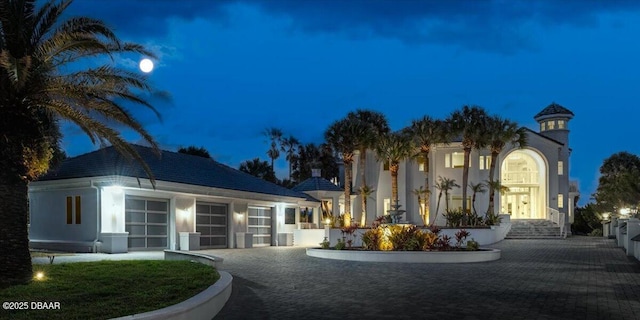 view of property with decorative driveway and a garage