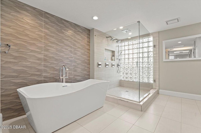 full bathroom featuring visible vents, baseboards, a stall shower, tile patterned floors, and a soaking tub