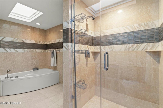 full bathroom featuring a skylight, a shower stall, a garden tub, tile walls, and tile patterned floors