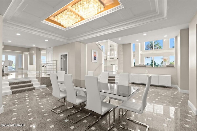 dining space featuring baseboards, a tray ceiling, recessed lighting, crown molding, and a chandelier