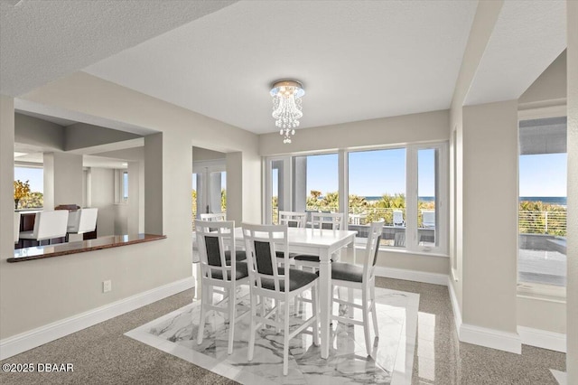 dining area featuring baseboards, plenty of natural light, and an inviting chandelier