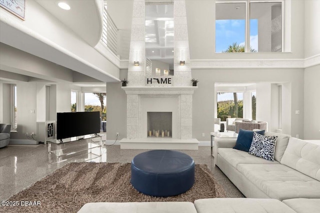 living room with a wealth of natural light, baseboards, a towering ceiling, and granite finish floor