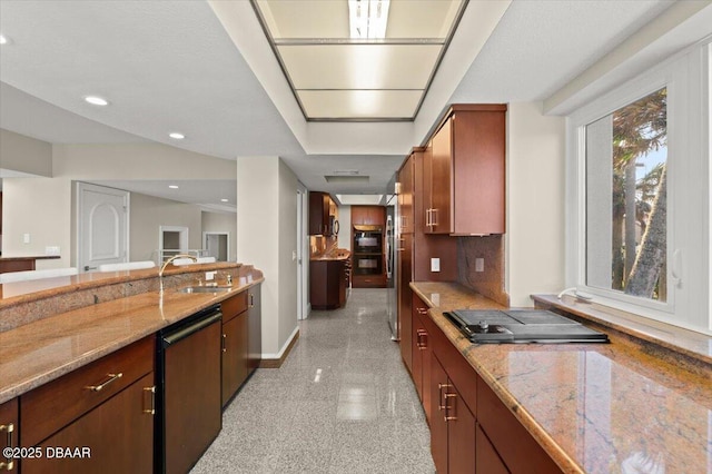 kitchen featuring light stone counters, tasteful backsplash, granite finish floor, recessed lighting, and baseboards