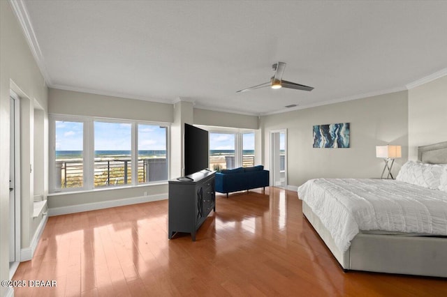 bedroom with visible vents, baseboards, light wood-style floors, and crown molding