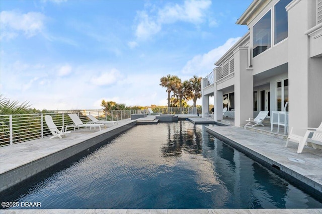 view of pool with a patio and a pool with connected hot tub