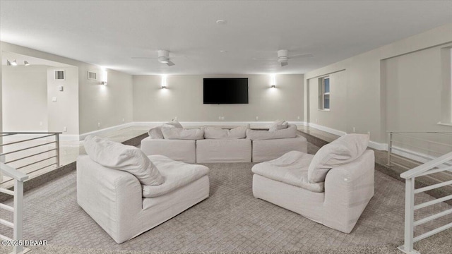 living area featuring visible vents, baseboards, and ceiling fan