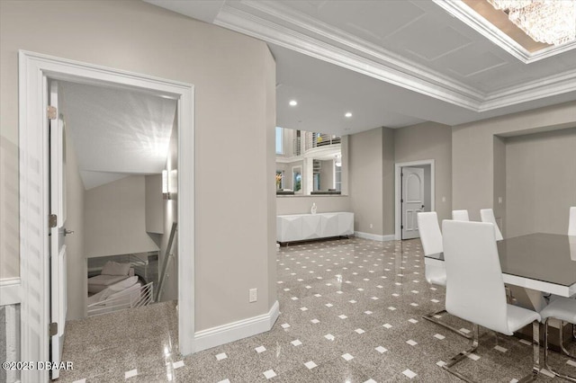 carpeted dining room with an inviting chandelier, crown molding, and baseboards