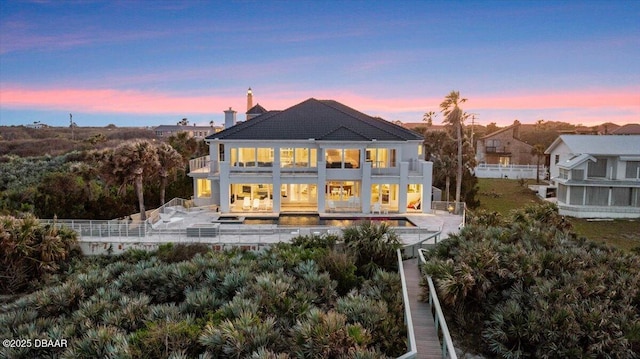 rear view of house featuring a patio, a balcony, fence, and a fenced in pool