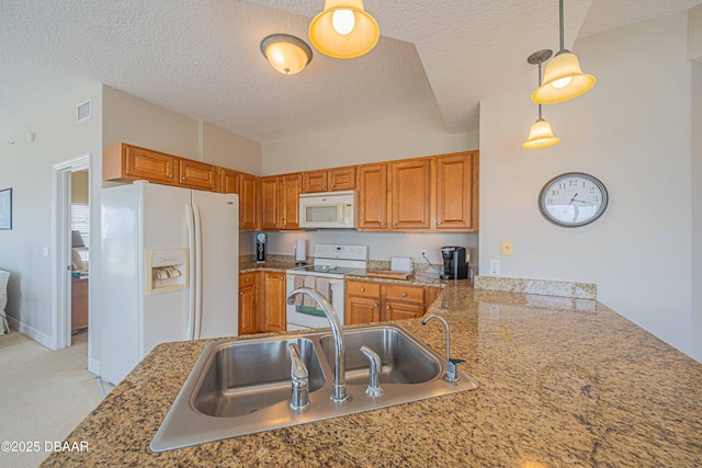 3756 S Atlantic Ave Unit 101, Daytona Beach, FL 32118 - kitchen with brown cabinets, a sink, visible vents, white appliances, and a textured ceiling