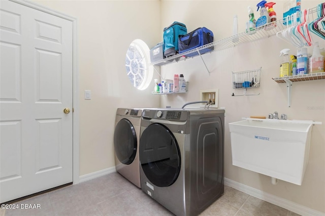 laundry area featuring sink, independent washer and dryer, and light tile patterned floors