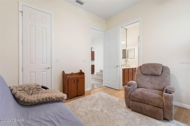 bedroom with light hardwood / wood-style floors and ensuite bathroom