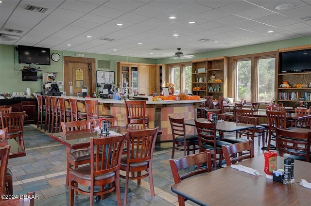 dining room featuring ceiling fan and a drop ceiling