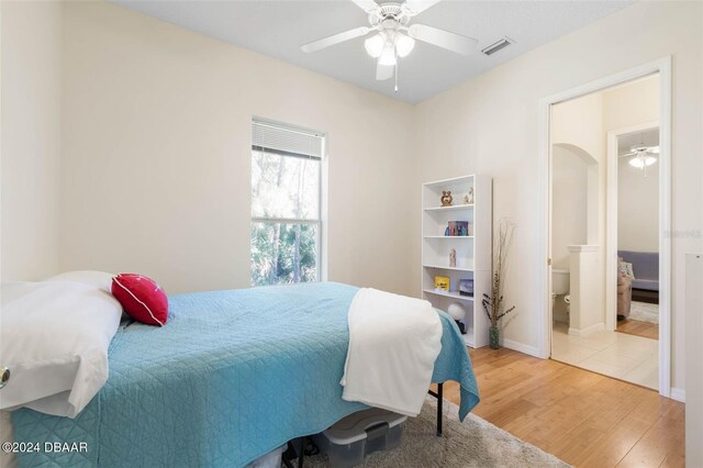 bedroom featuring hardwood / wood-style floors, ensuite bath, and ceiling fan