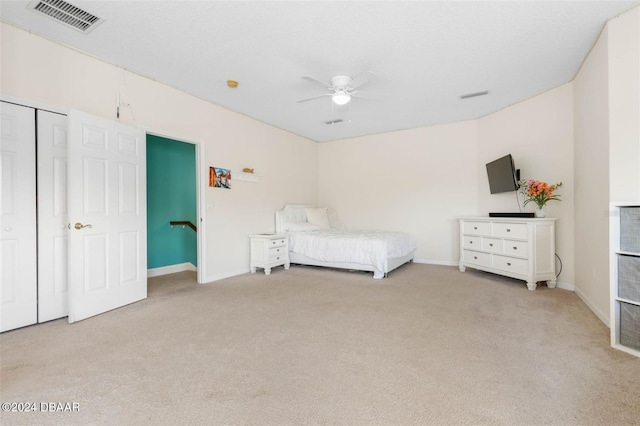 unfurnished bedroom featuring light colored carpet, ceiling fan, and a closet