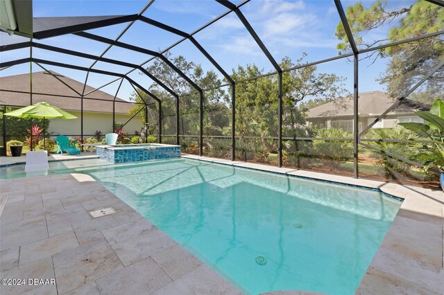 view of swimming pool featuring a patio area, a lanai, and an in ground hot tub