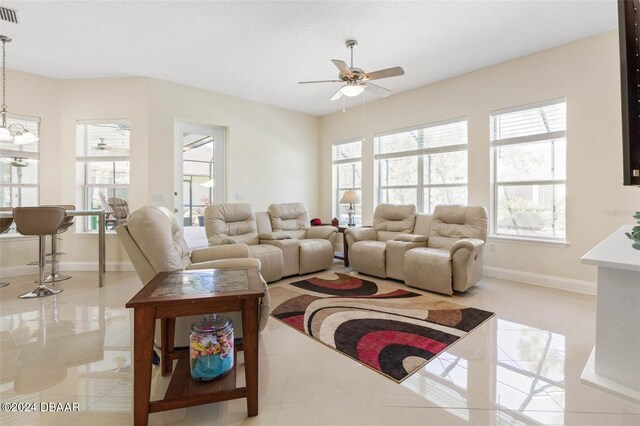 living room featuring ceiling fan and a textured ceiling